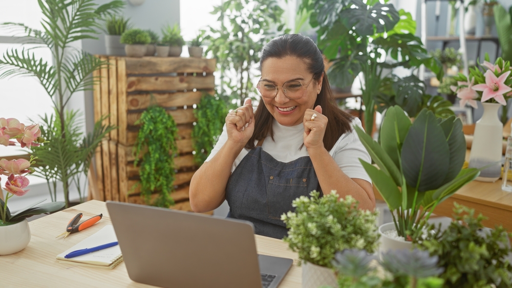 Smiling,Hispanic,Woman,Enjoying,Success,In,A,Flower,Shop,Surrounded